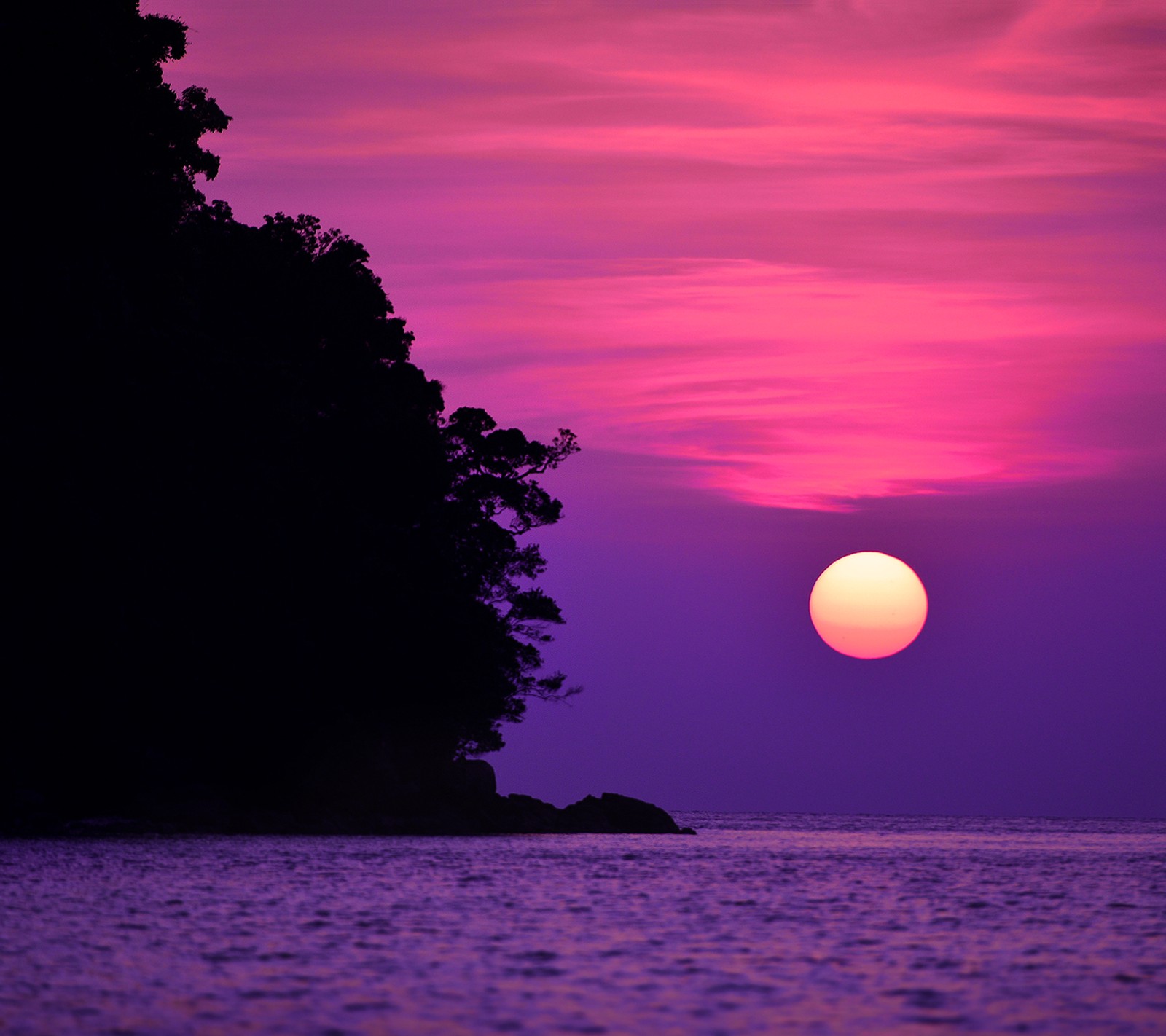 Pôr do sol roxo e rosa sobre o oceano com um barco na água (paisagem, rosa, mar, sol, por do sol)