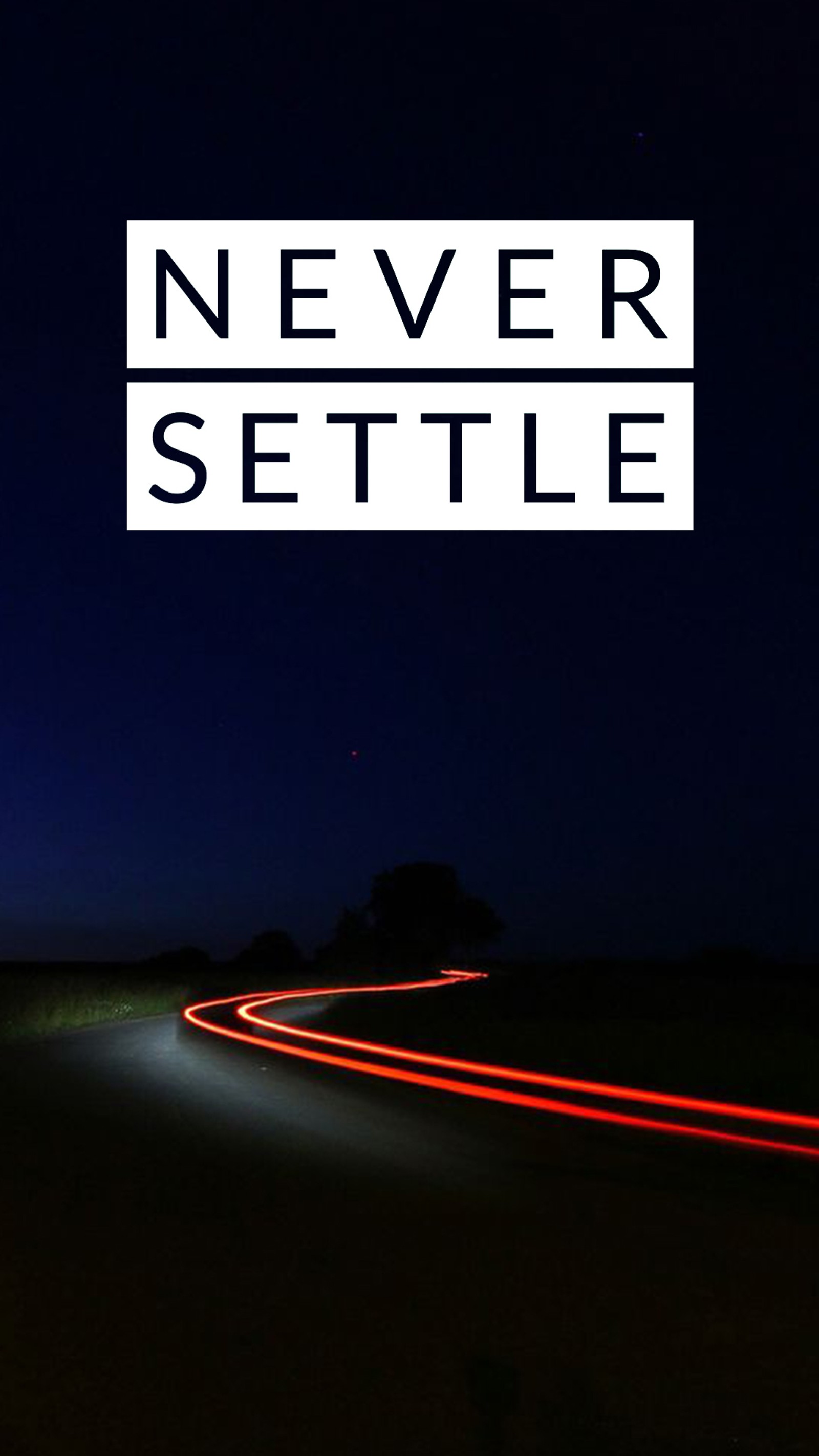 Un gros plan d'une rue avec une voiture roulant dessus la nuit (ne jamais se contenter, never settlenever settle)