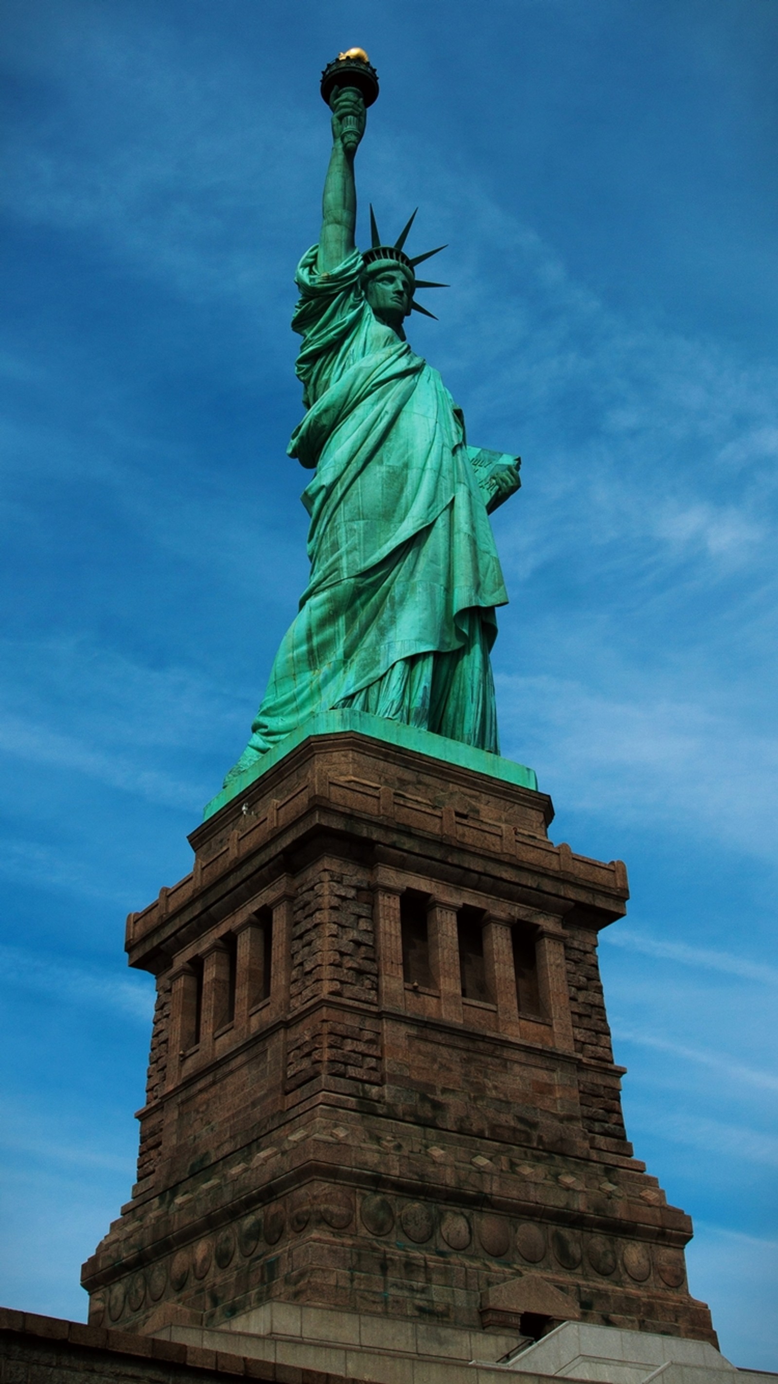 Um close da estátua da liberdade contra um céu azul (américa, liberdade, nova york, new york city, ny)