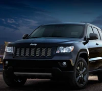 Jeep Grand Cherokee negro al anochecer con el horizonte de la ciudad de fondo.