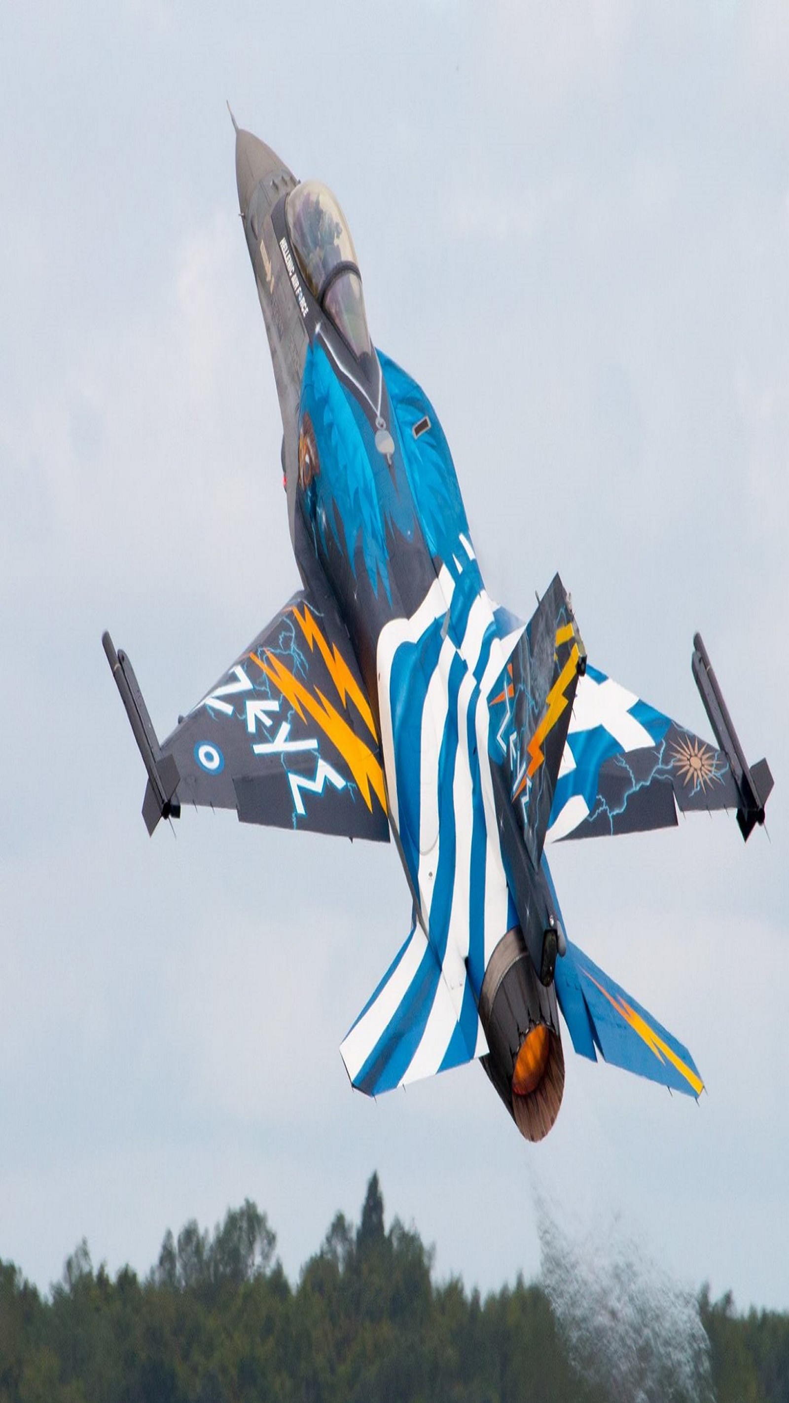 There is a blue and yellow jet flying in the sky (f 16, f16, greece, greek, greek air force)