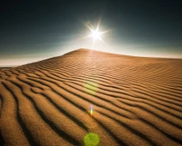 Lever de soleil sur des dunes de sable ondulantes