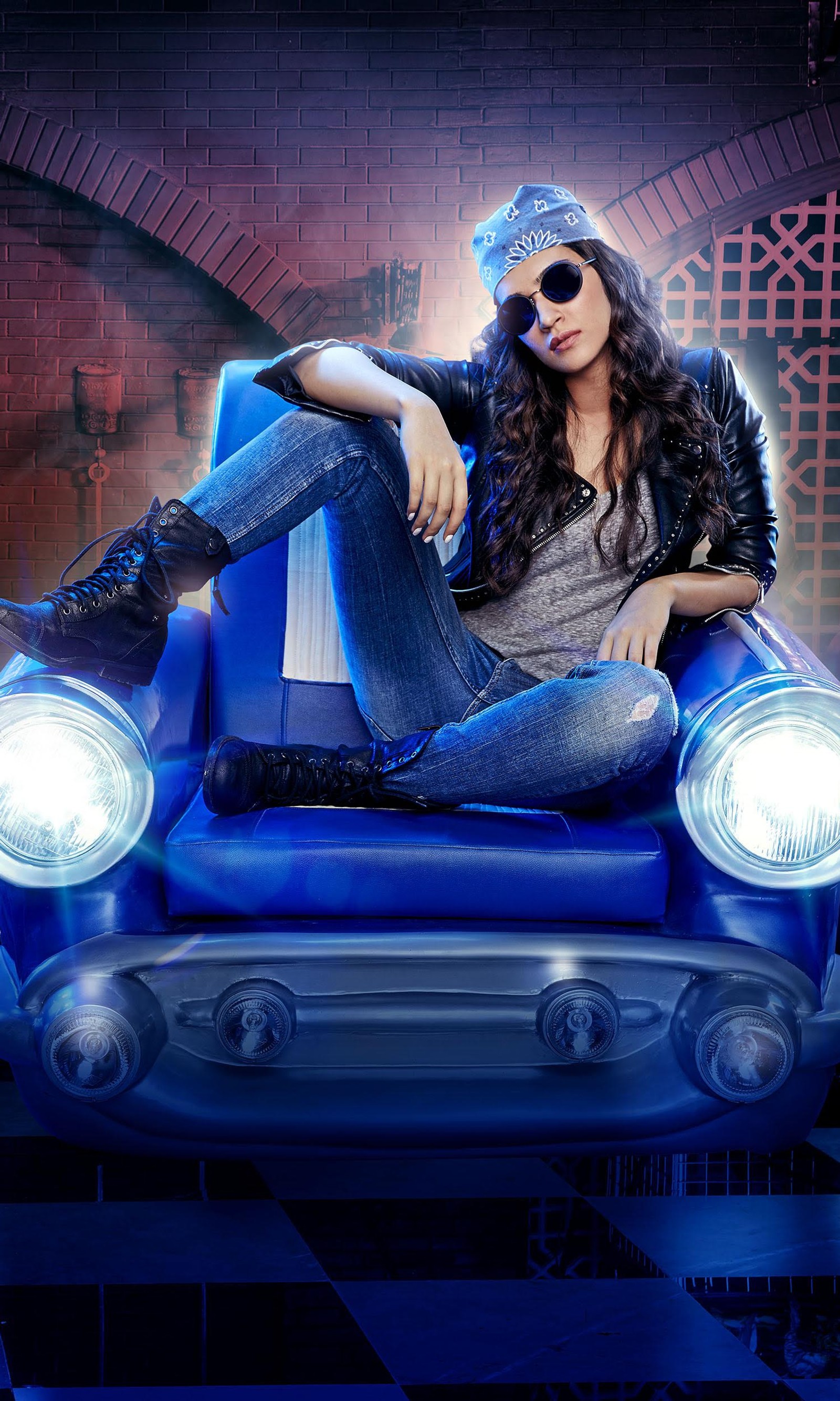 Une femme assise sur une voiture bleue avec un chapeau et des lunettes de soleil (fashiom, fille, jeans, kriti, élégant)