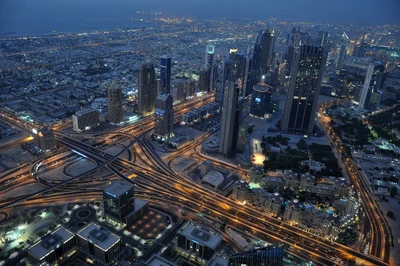 A stunning bird's eye view of Dubai's skyline at dusk, featuring the iconic Burj Khalifa and Burj Al Arab, showcasing a vibrant metropolis with intricate road networks and twinkling city lights.