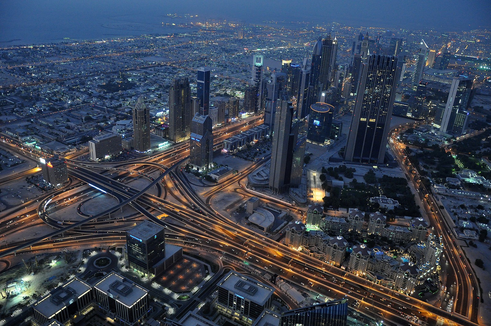 Uma vista aérea de uma cidade à noite com uma rodovia e uma estrada (burj khalifa, cidade, paisagem urbana, área urbana, metrópole)