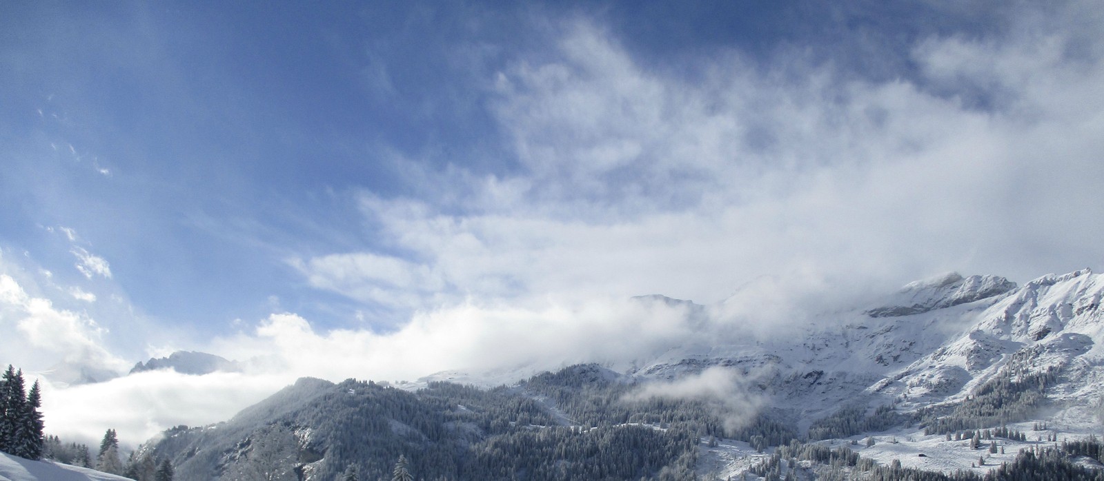 Des skieurs sur une pente enneigée avec une montagne en arrière-plan (chaîne de montagnes, montagne, crête, alpes, formes montagneuses)