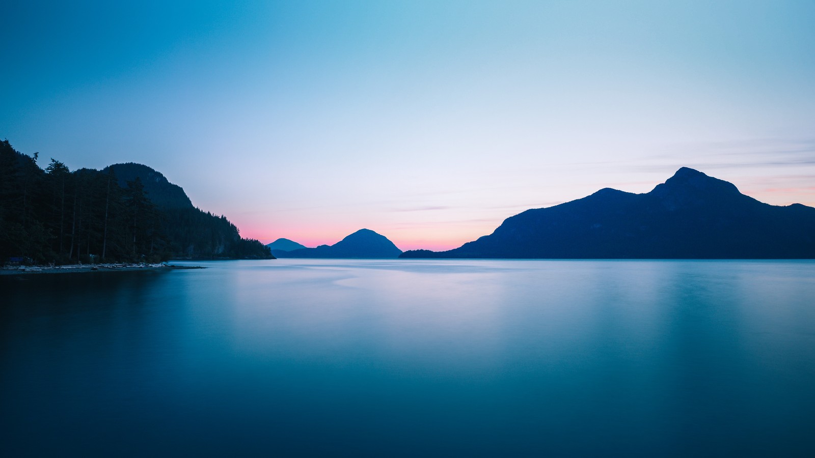 Uma foto de longa exposição de um lago com montanhas ao fundo (parque, corpo de água, azul, natureza, água)