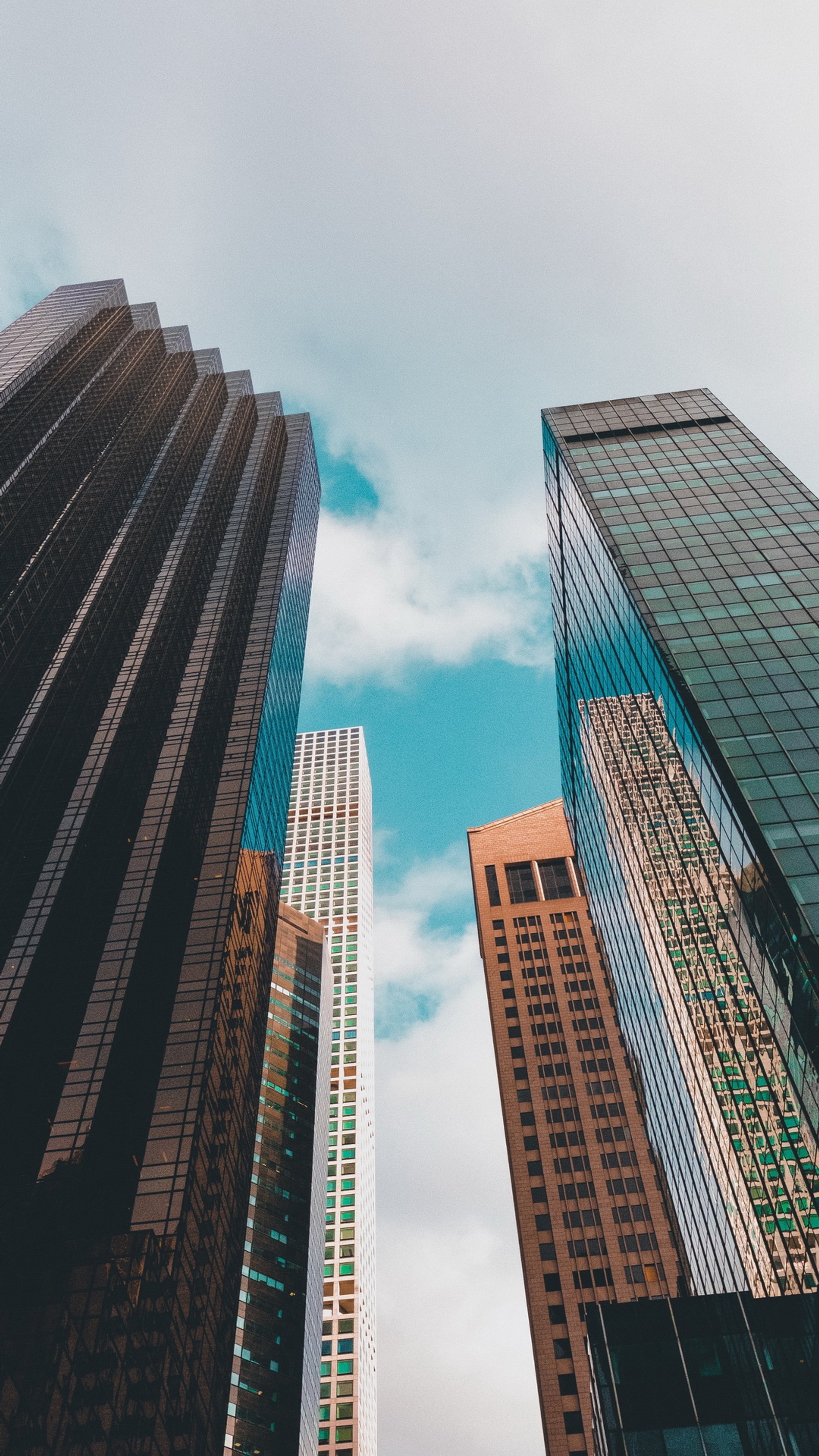 Edifícios altos em uma cidade com um céu azul ao fundo (arranha céus, nuvem, edifício, dia, bloco de torre)