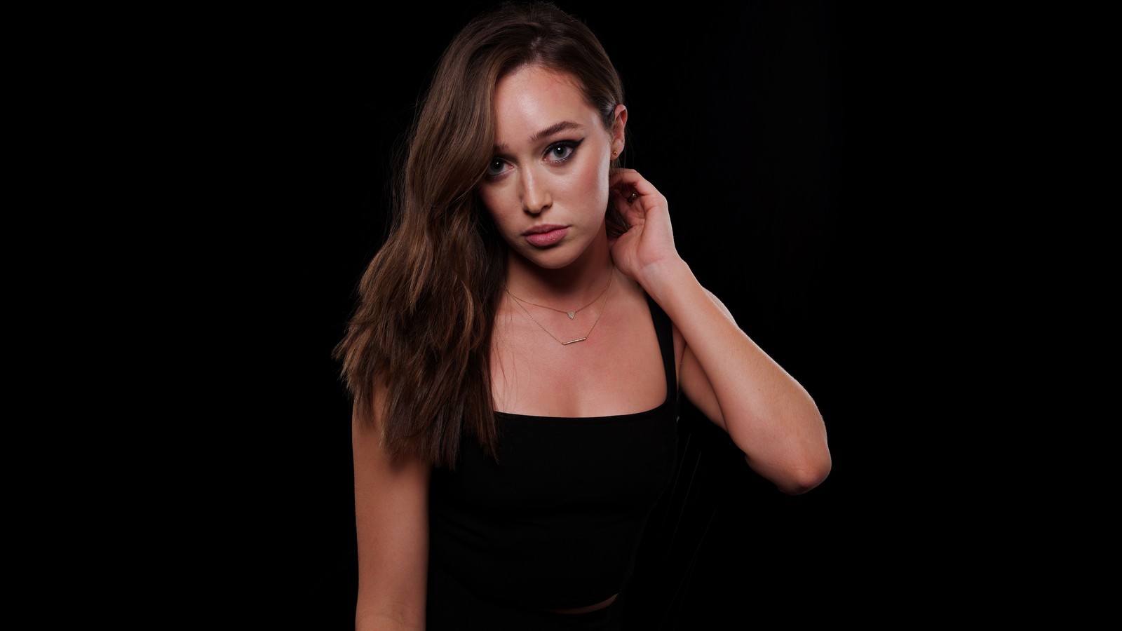 Un gros plan d'une femme en haut noir posant pour une photo (alycia debnam carey, arrière plan noir, 8k, amoled, 5k)