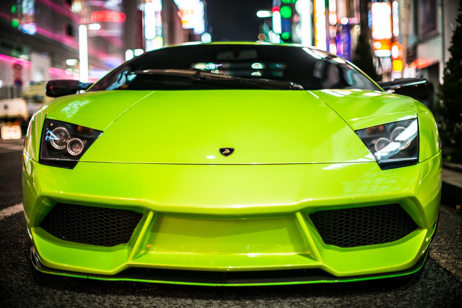 A close up of a green sports car parked on a city street (lamborghini murcilago, sports car, lamborghini gallardo, car, lamborghini)