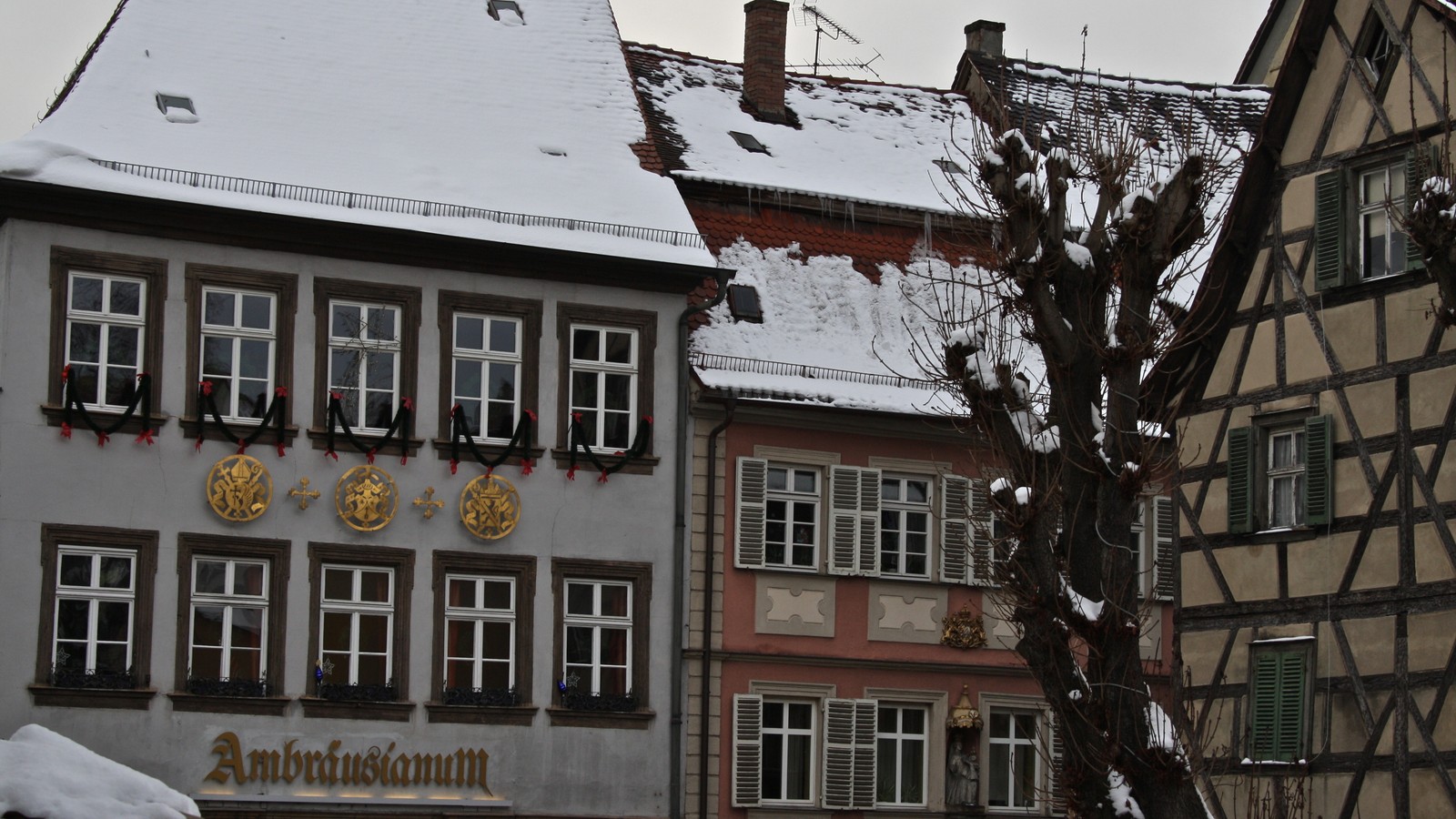 There is a building with a clock on it in the snow (winter, tree, window, design, building)