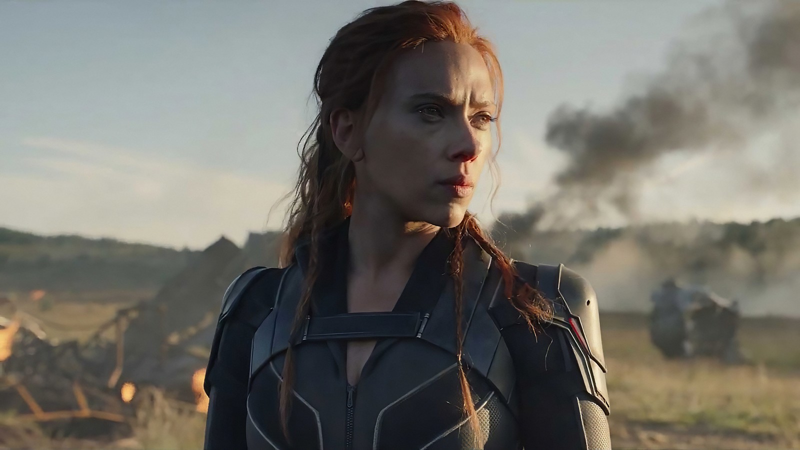 Una mujer con un traje de viuda negro de pie en un campo (viuda negra 2020, black widow 2020, película, natasha romanoff, viuda negra)