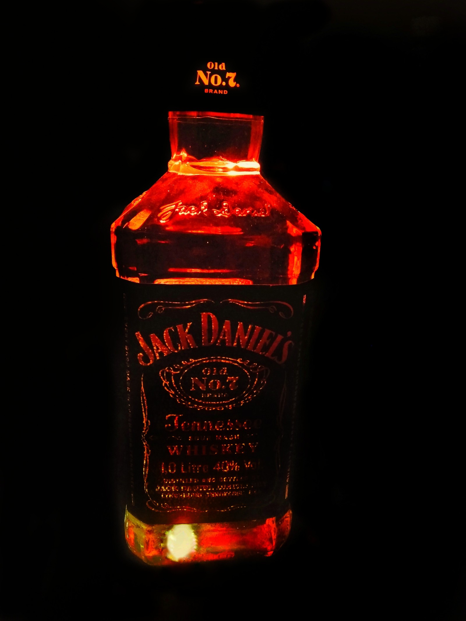 Arabische flasche jack daniels whiskey, die im dunkeln beleuchtet ist (alchohol, getränk, jack daniels, liebe, stimmung)