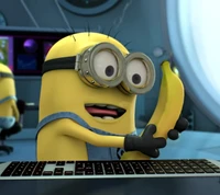 A cheerful minion joyfully holding a banana while sitting at a keyboard in a colorful, high-tech environment.