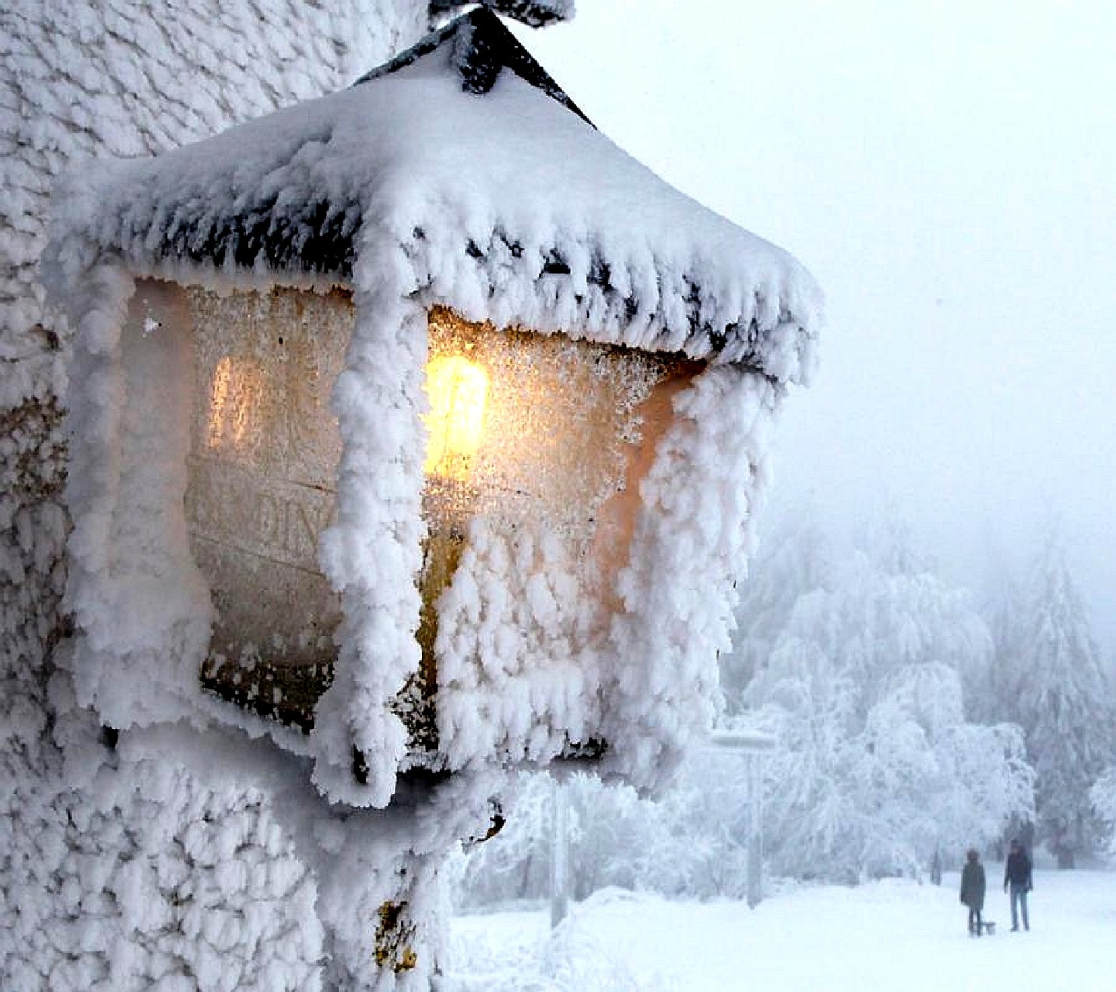 Une lumière recouverte de neige sur un poteau (hiver)