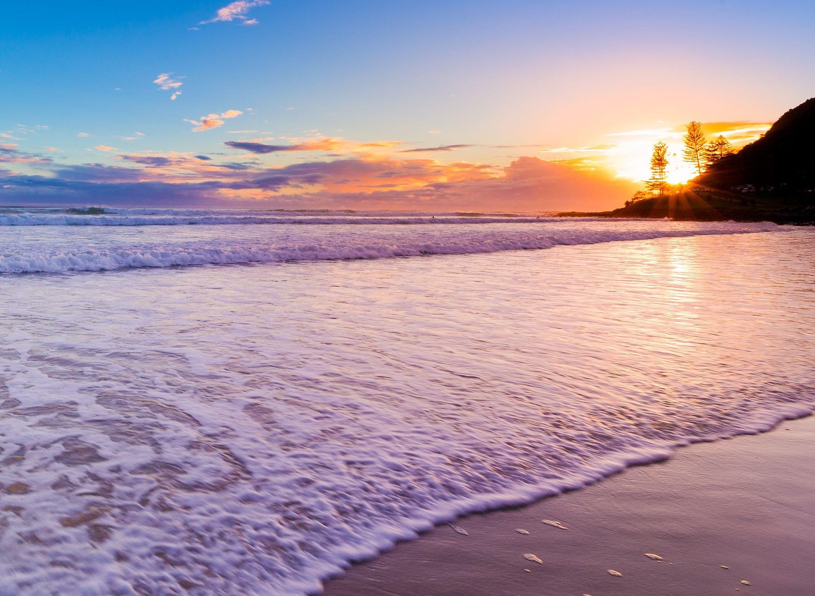 Una vista de una playa con olas y un atardecer (playa, paisaje, naturaleza, agradable)