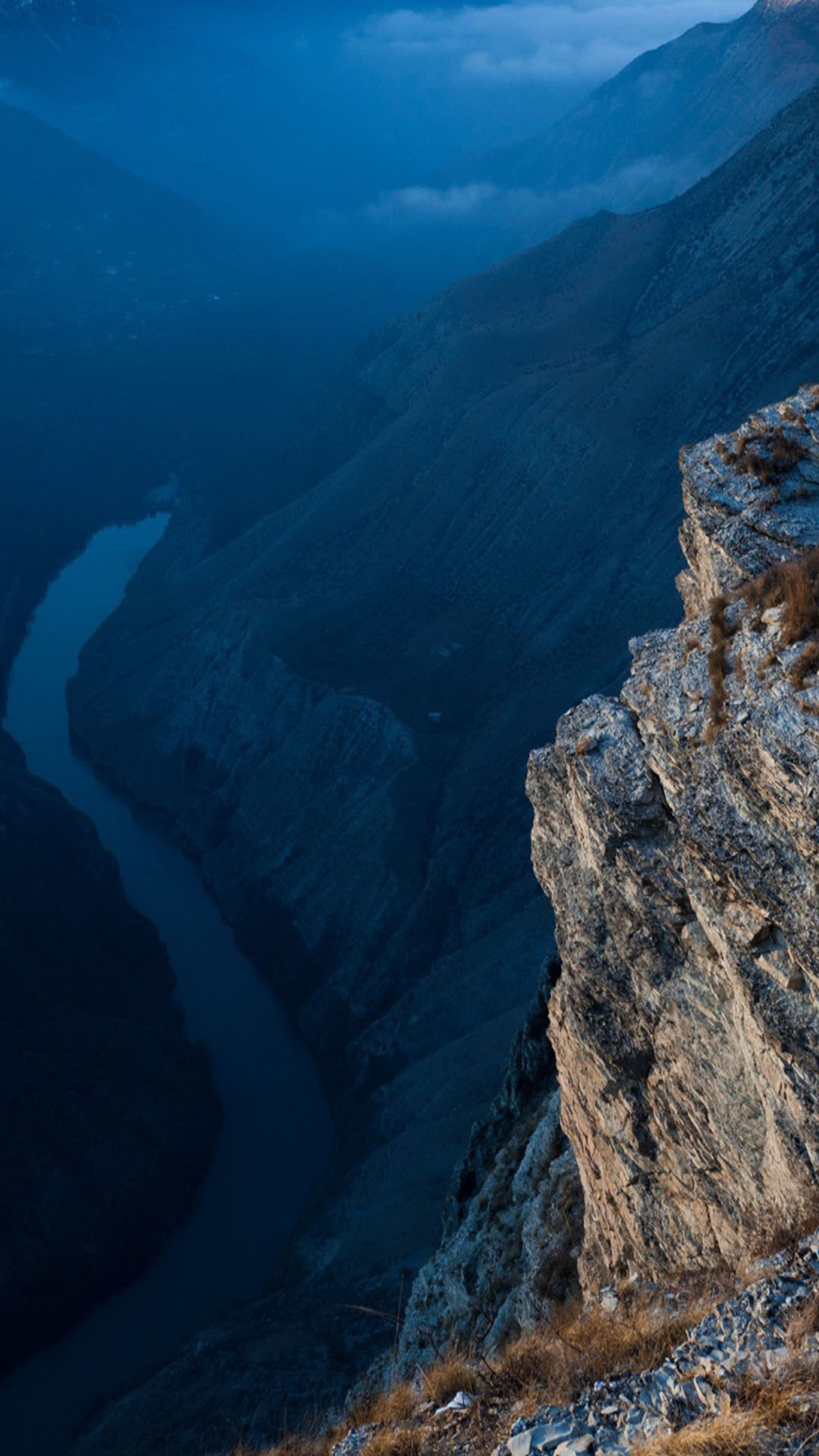 There is a man standing on a cliff overlooking a valley (river, valley)