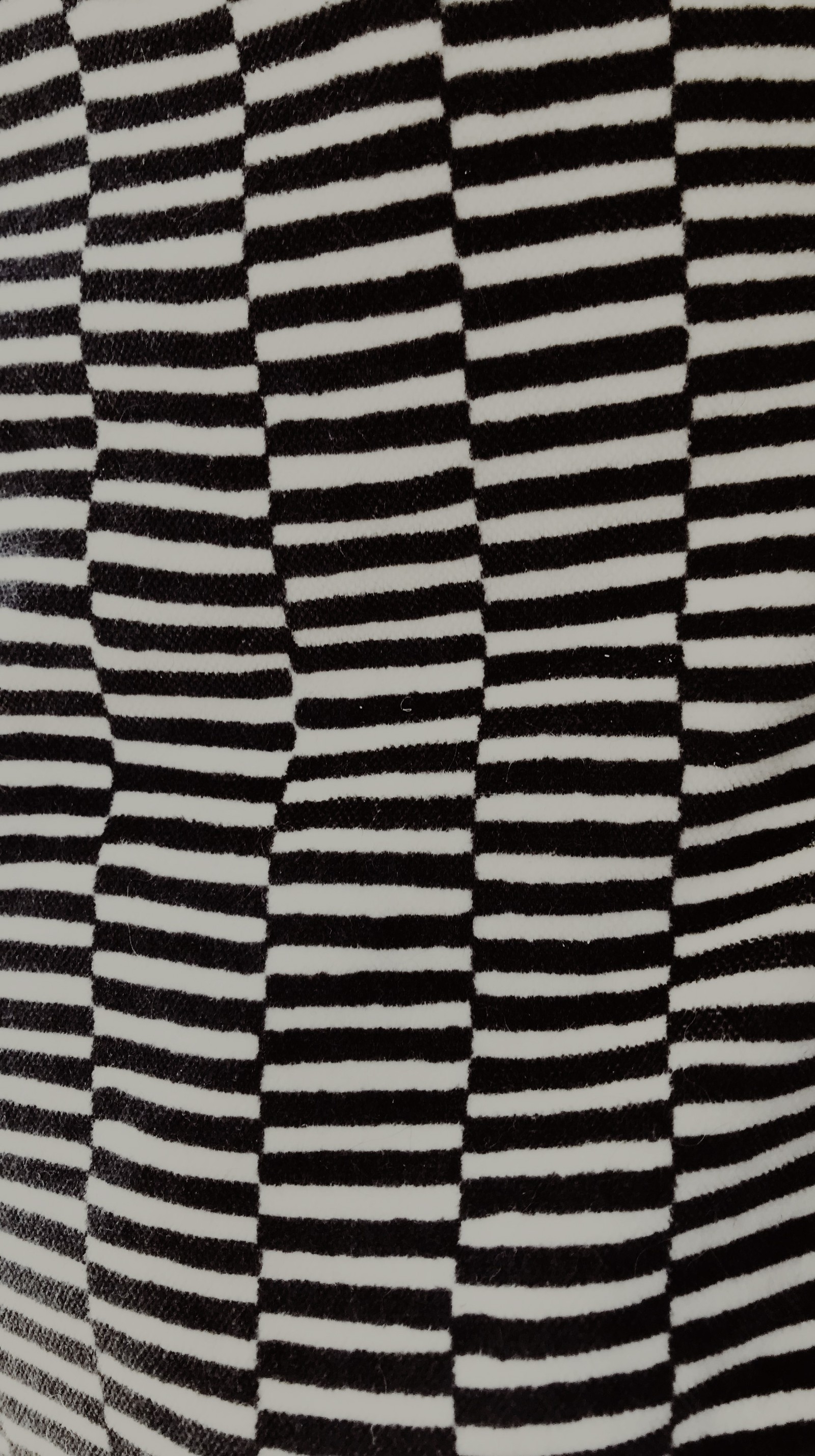 A close up of a black and white striped fabric with a black and white stripe (bumpy, checker, crazy, fabric, pattern)