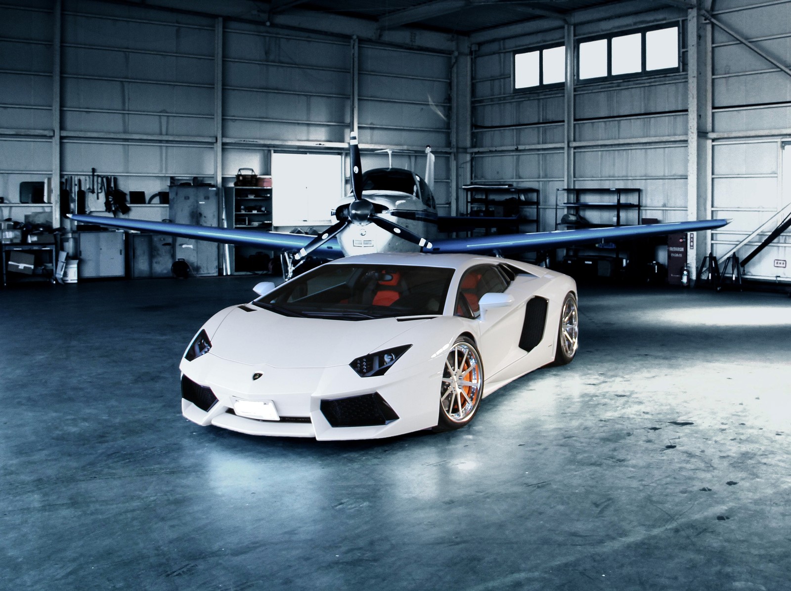 Um carro esportivo branco estacionado em uma garagem com um avião ao fundo (carro, lamborghini, corridas, esporte, sintonizado)