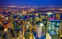 Eine atemberaubende nächtliche Stadtlandschaft von Manhattan, die eine lebendige Skyline zeigt, die von Stadtlichtern erleuchtet wird, und einen atemberaubenden Blick auf den Horizont über dem Wasser.