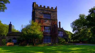 Casa de estilo victoriano rodeada de exuberante vegetación y un cielo azul claro.