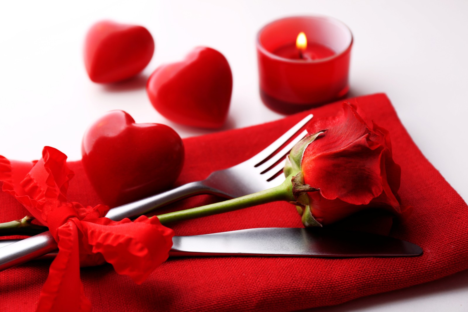 Hay una rosa en una servilleta roja con un tenedor y un cuchillo (día de san valentín, pétalo, flor, rosa, amor)