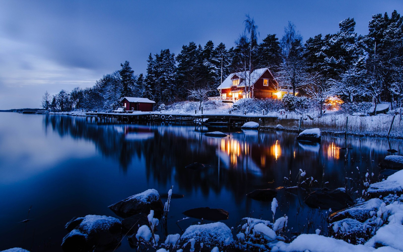 Aussicht auf eine hütte an einem verschneiten see bei nacht (stockholm, schnee, winter, reflexion, natur)