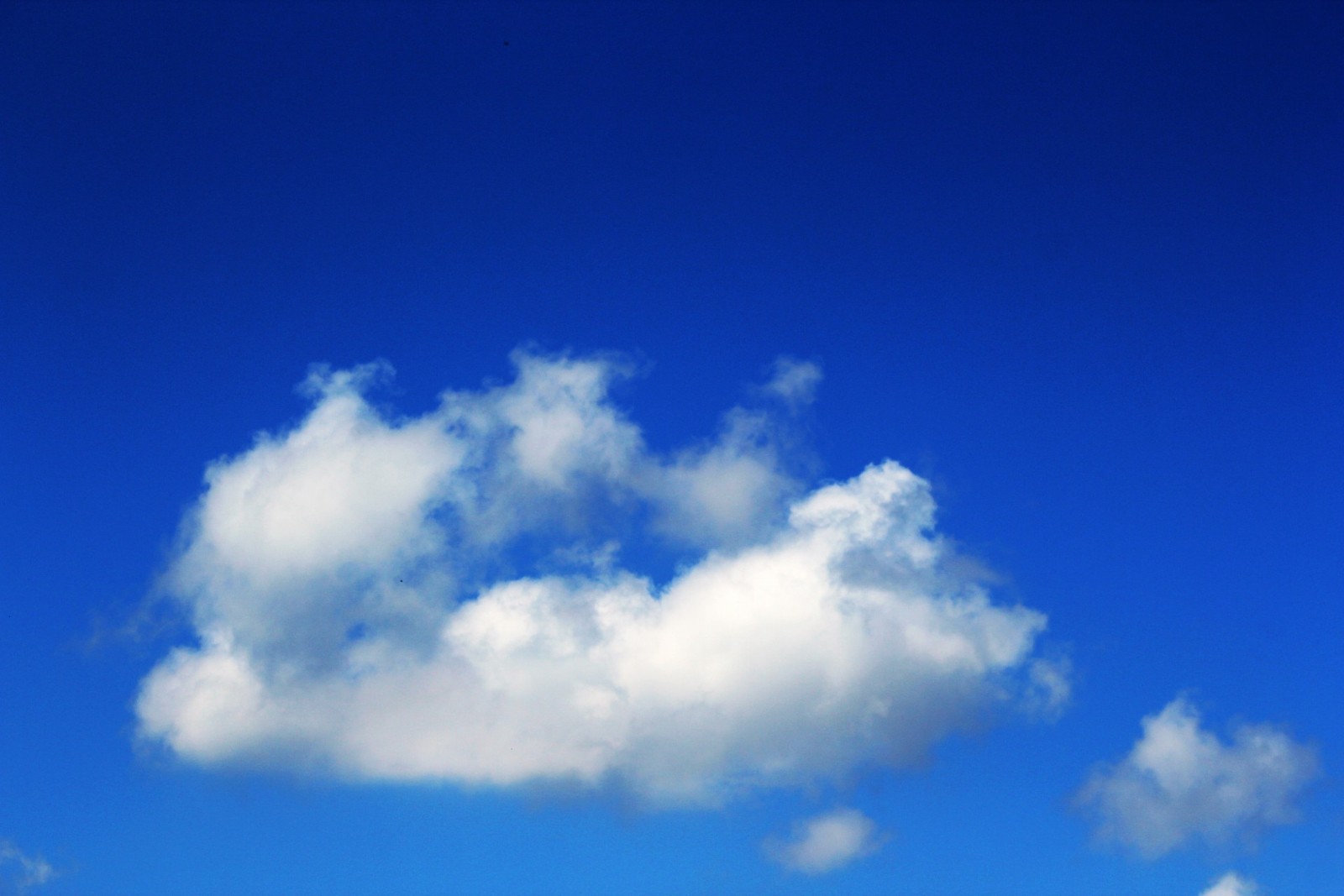 Un grand nuage dans le ciel au-dessus d'un champ (bleu, cumulus, azur, nuage, journée)