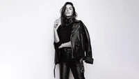 Ana de Armas dans une veste en cuir noir élégante et une tenue ajustée, capturée dans un portrait monochrome frappant.