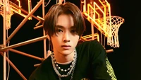 Sungchan von NCT U posiert selbstbewusst vor einem lebhaften, basketballthematischen Hintergrund und zeigt seinen einzigartigen Stil und Charisma.