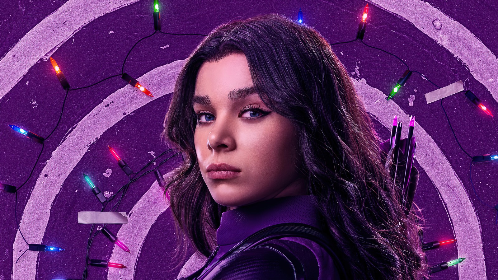 Une femme en chemise violette et pantalon noir devant un fond violet (la série hawkeye, série télévisée, kate bishop, hailee steinfeld)