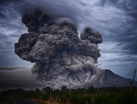 Éruption du mont Sinabung : nuage de cendres volcaniques s'élevant contre un ciel dramatique.