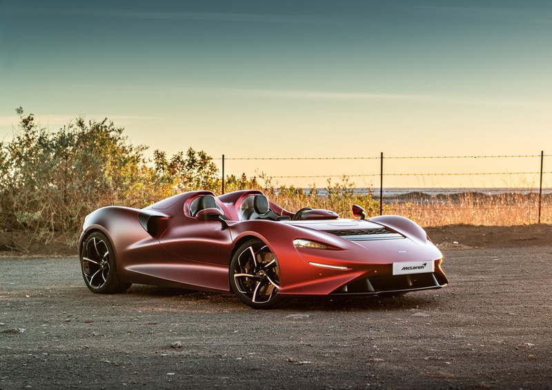 Красный спортивный автомобиль припаркован на стоянке рядом с забором (mclaren elva, 2021, 5k, машины, обои 4k)