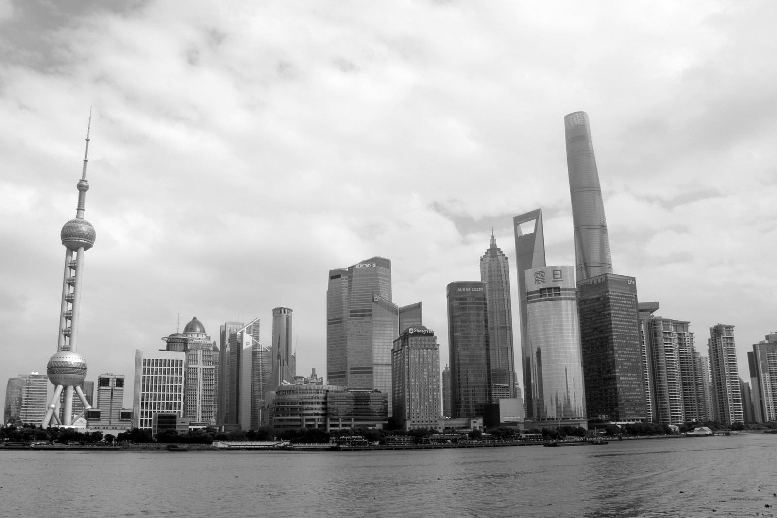 Vista aérea del horizonte de una ciudad con un alto edificio en el medio (ciudad, panorama, blanco y negro, rascacielos, paisaje urbano)