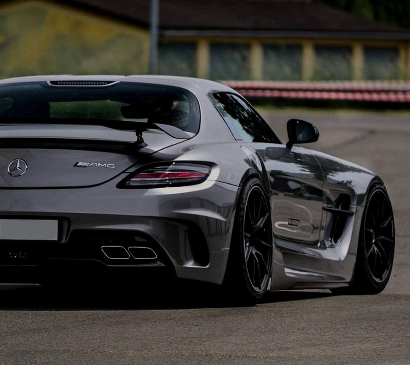 A close up of a car driving on a track with a house in the background (amg, car, luxury, mercedes)