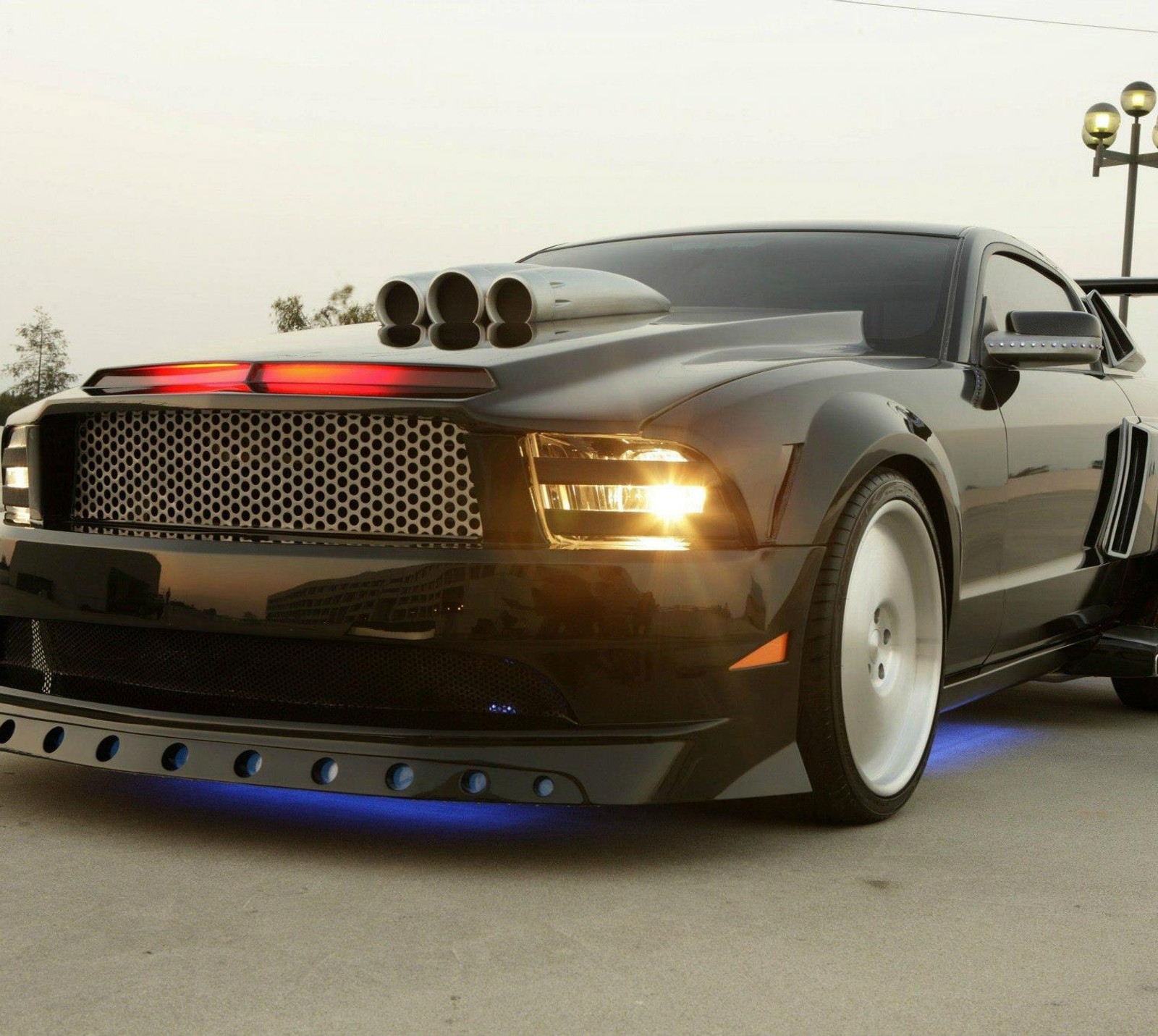 A close up of a black mustang with a blue light on the hood (car, ford mustang, vehicle)