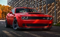 Elegante Dodge Challenger SRT rojo en una pista iluminada por el sol