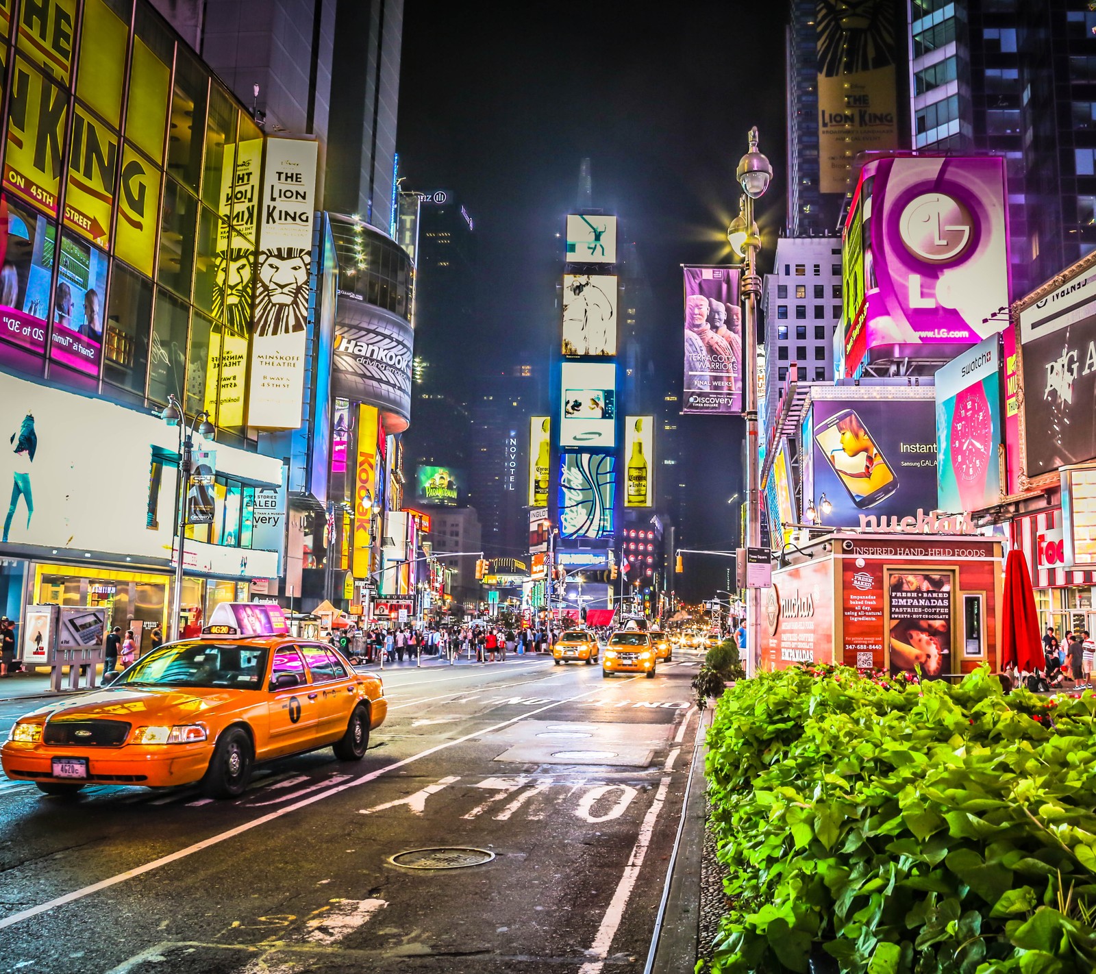 Eine sicht auf eine belebte stadtstraße bei nacht mit einem taxi (stadt, new york, nacht, wolkenkratzer, usa)