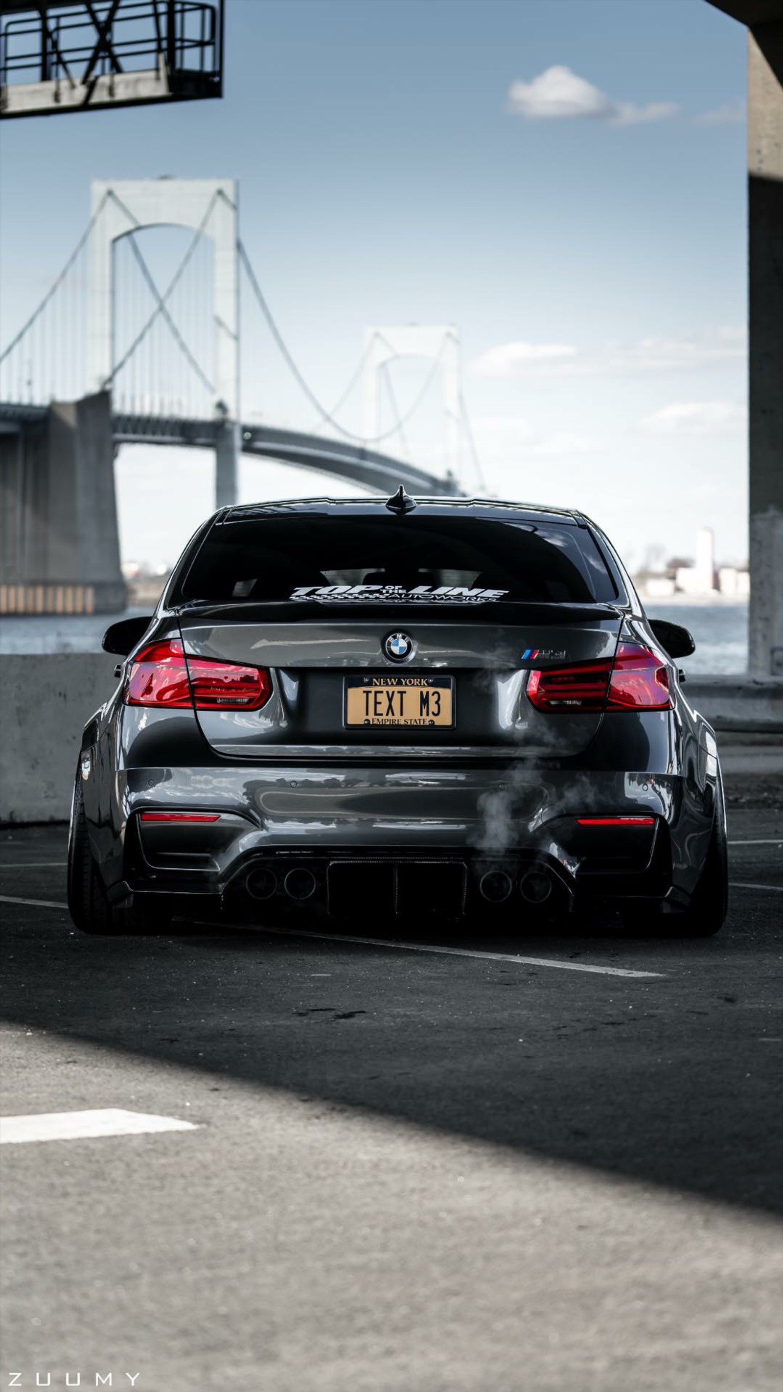 Un bmw estacionado en una carretera con un puente de fondo (bmw, m4, negro, coche, supercoche)