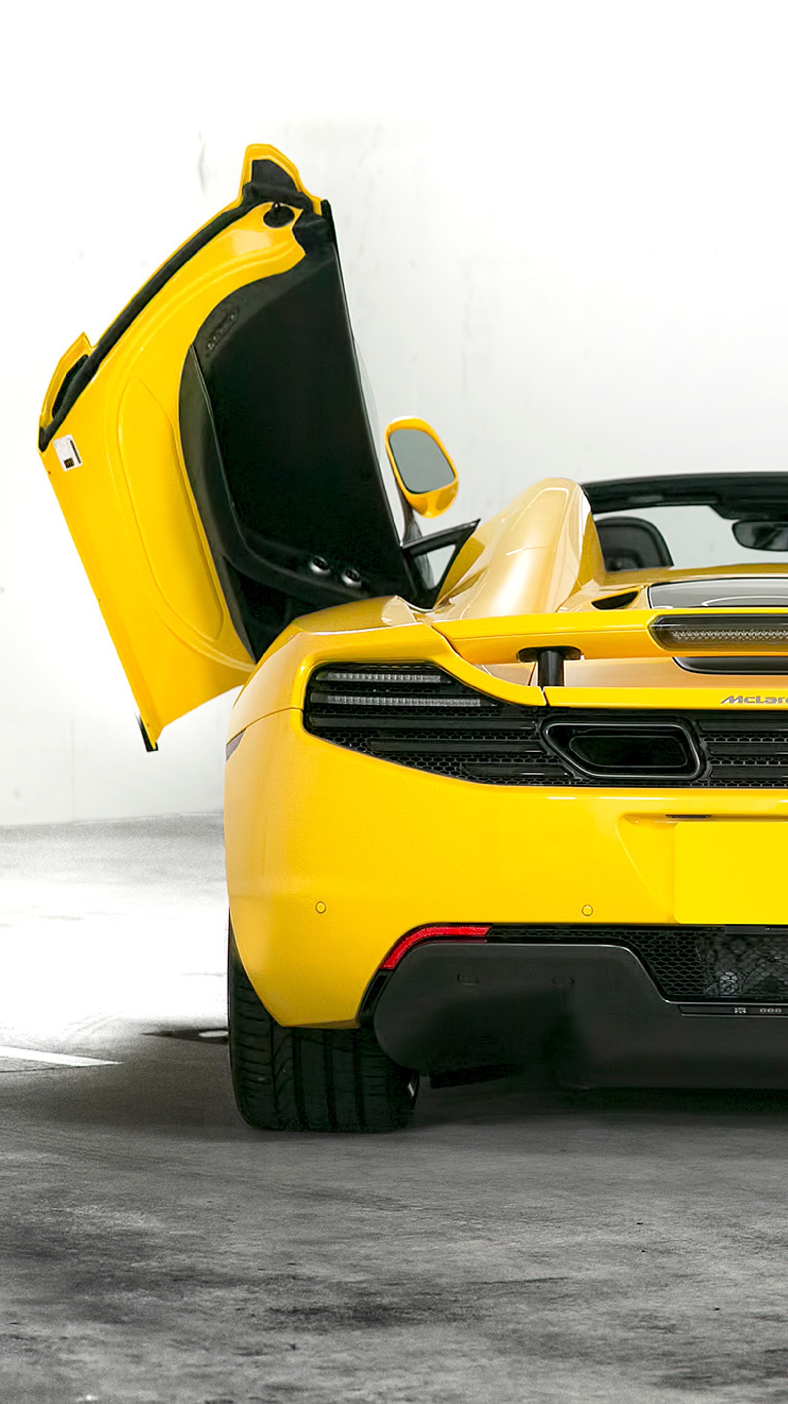 Gros plan d'une voiture de sport jaune avec les portes ouvertes (canon, exotiques, mclaren, spyder, supersportive)