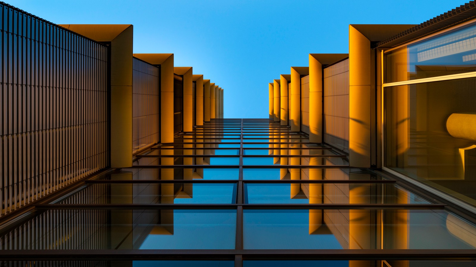 A view of a building with a lot of windows and a chair (modern architecture, look up, reflection, glass building, symmetrical)