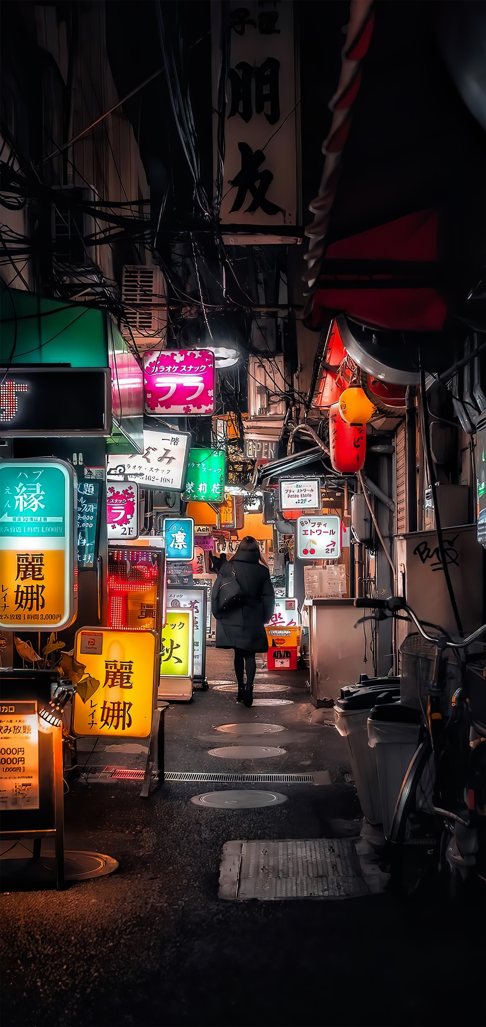 There is a person walking down a street at night (night, street, infrastructure, automotive lighting, architecture)