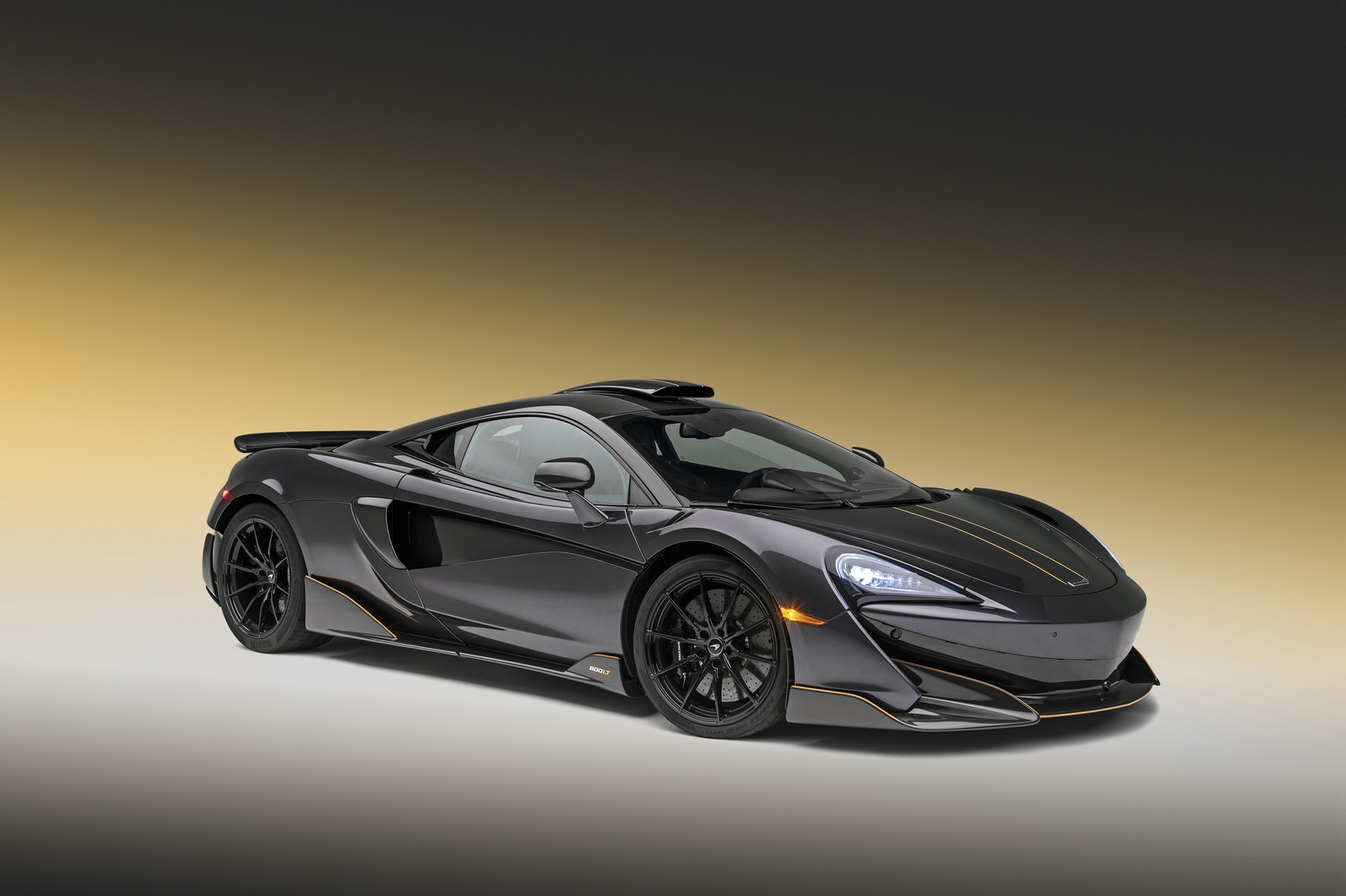 Um close em um carro esportivo preto em um fundo amarelo (mclaren automotive, mclaren, carro, carro esportivo, supercarro)