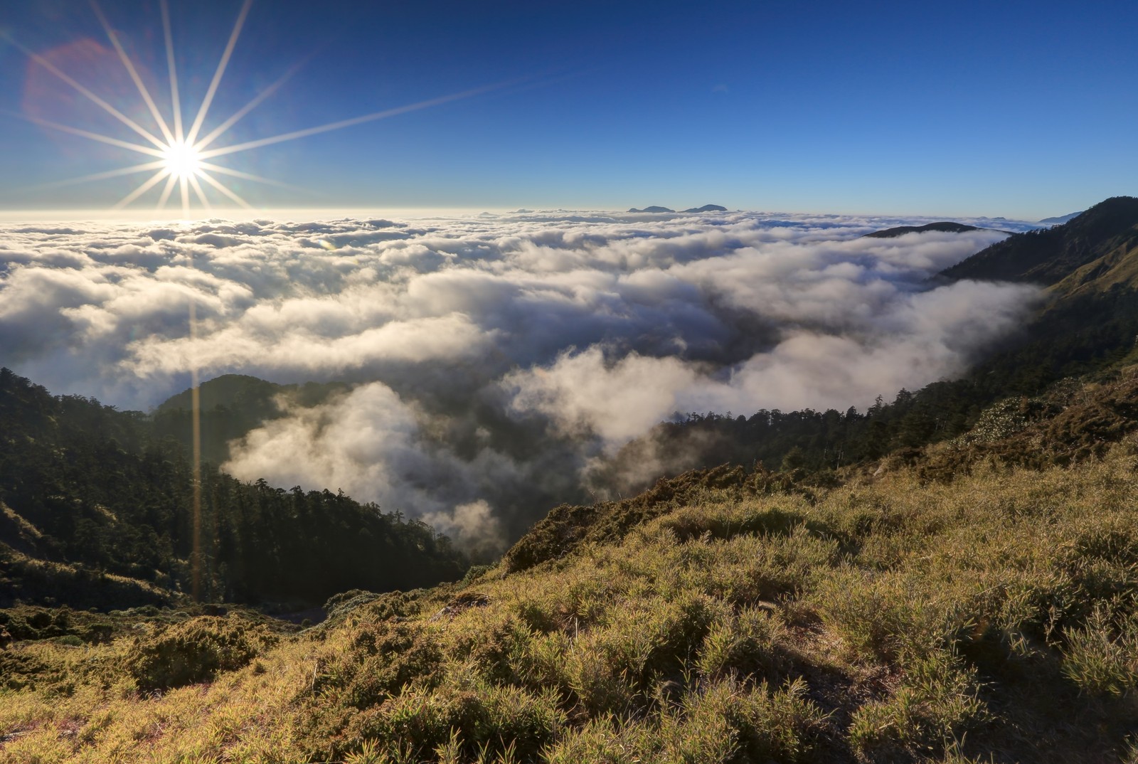 Uma vista de uma montanha com o sol brilhando sobre as nuvens (cadeia de montanhas, terras altas, montanha, formas montanhosas, wild)