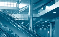 Modern leisure center interior featuring sleek escalators, glass and steel architecture, and a focus on symmetry and daylighting.