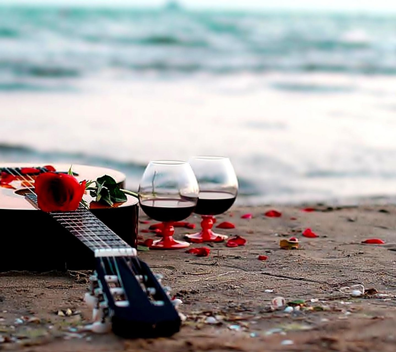 Il y a une guitare et un verre de vin sur la plage (rose rouge, papier peint)