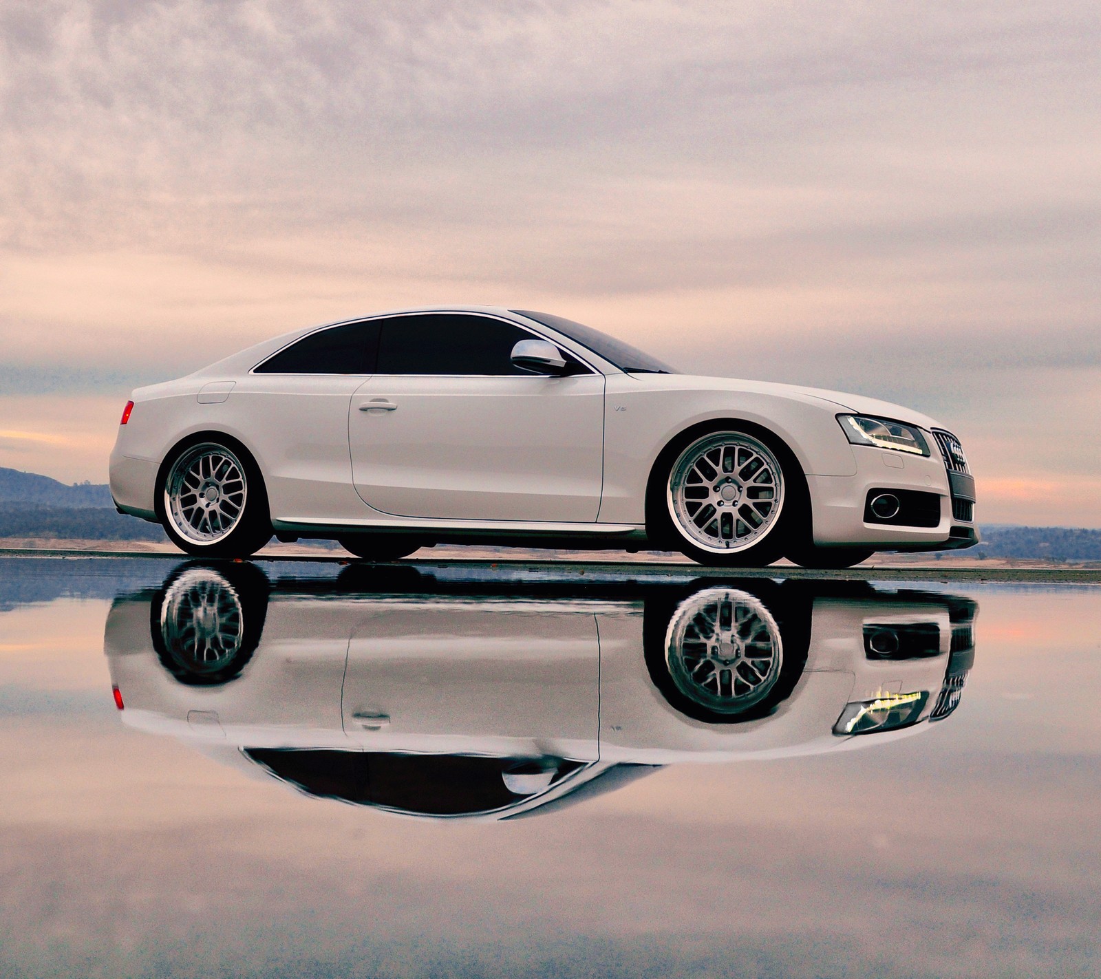 A close up of a white car parked on a reflective surface (audi, car, new, s5, white)