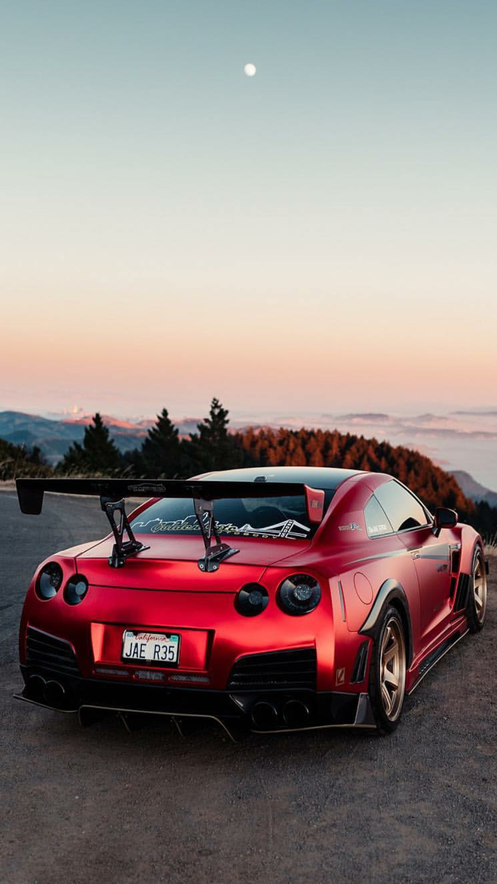 Arafed red sports car parked on a mountain road with a full moon in the background (nissan, gtr, red, car, supercar)