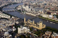 Vue aérienne de la Tamise serpentant à travers Londres, mettant en valeur l'emblématique Big Ben et le Palais de Westminster, entourés d'un paysage urbain vibrant.