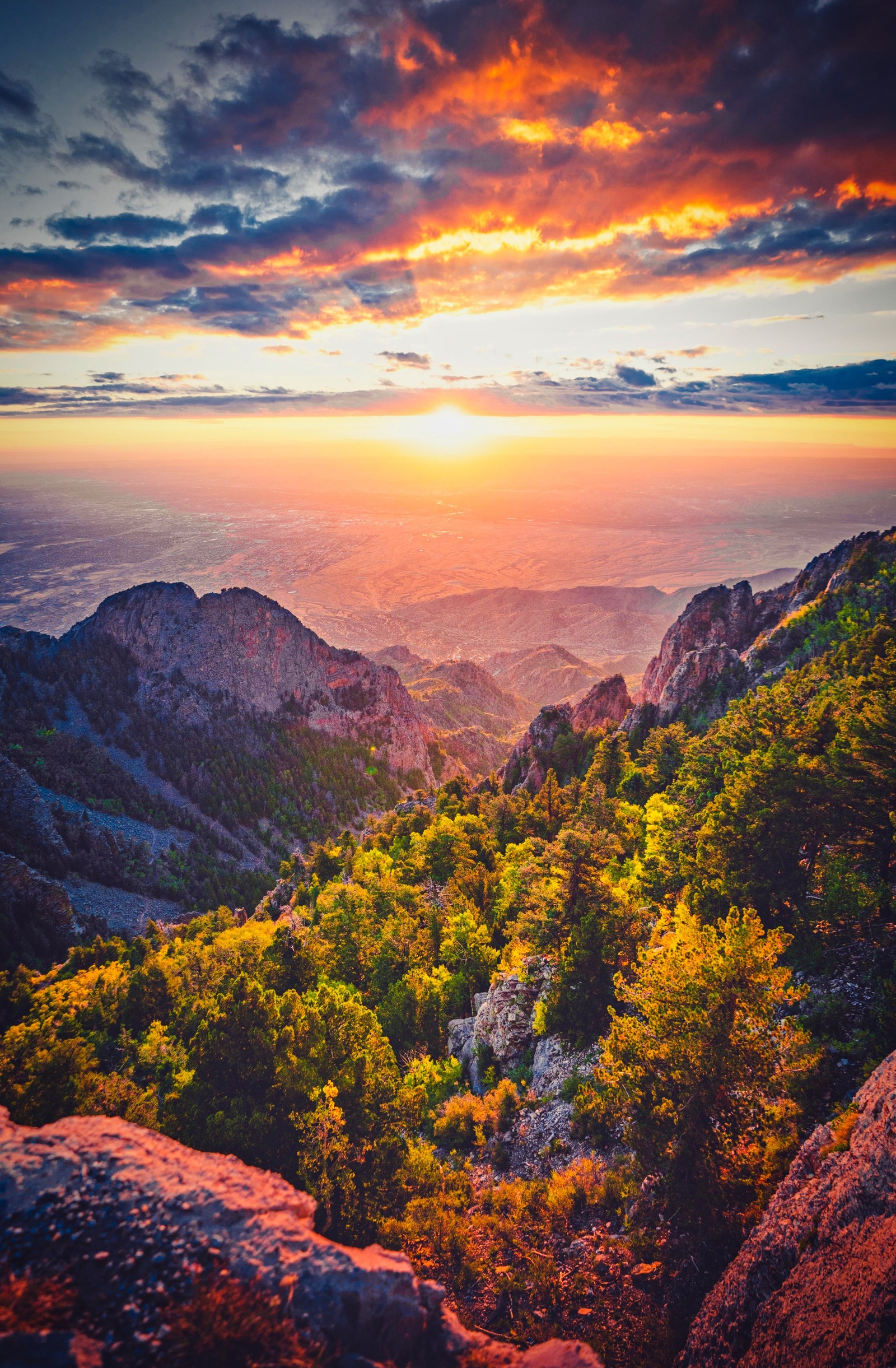 Arafed view of a mountain range with a sunset in the distance (mountain, nature, mountain range, cloud, atmosphere)